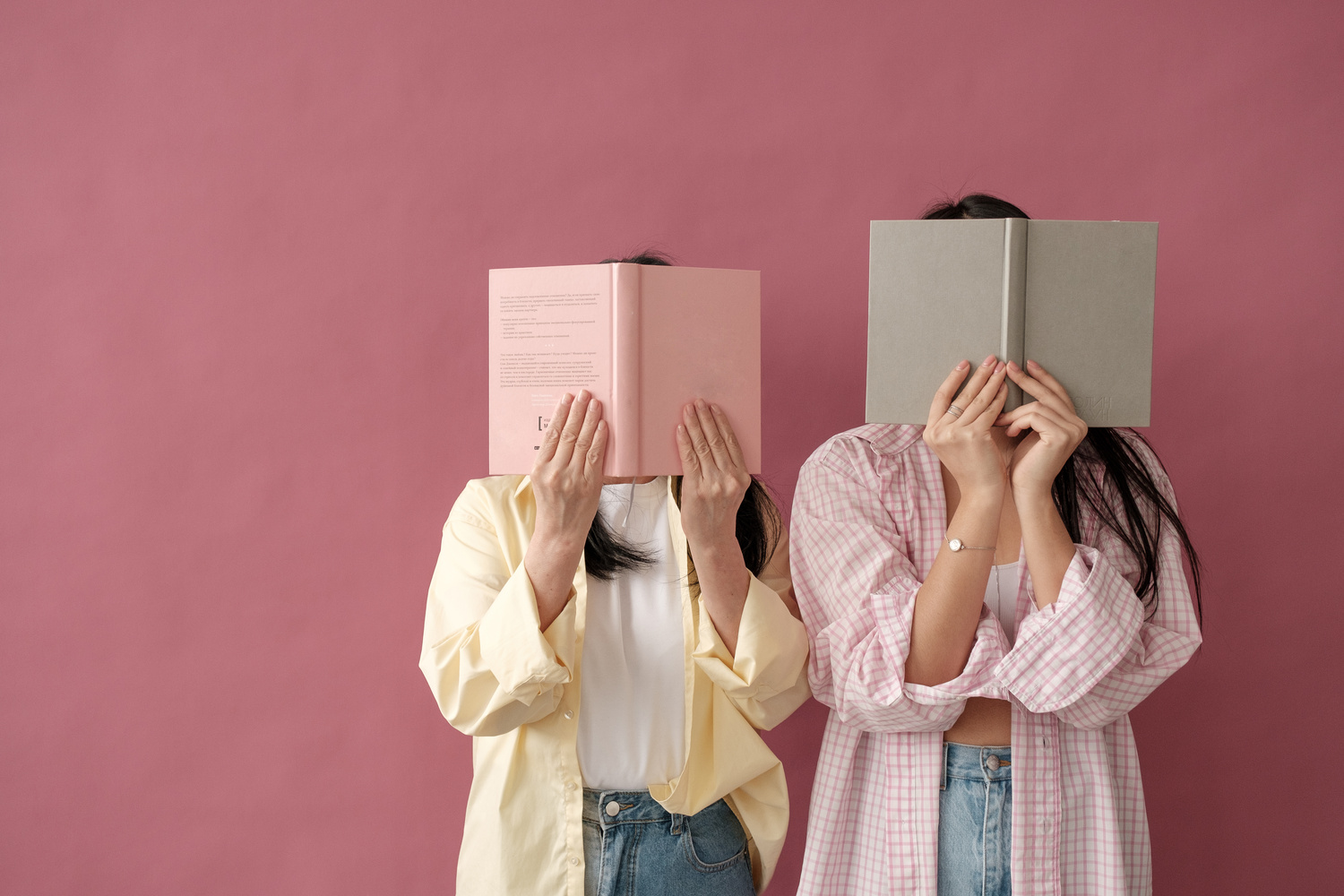 Mom and Daughter in Matching Outfits Covering Face with Book